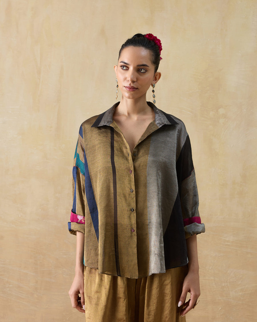 The Firefly Shirt, a loose multicoloured striped metallic tissue shirt, worn with gold trousers.