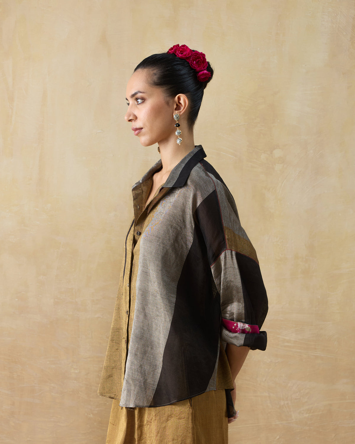 Side view of a metallic Firefly shirt with magenta lining at the rolled cuffs.