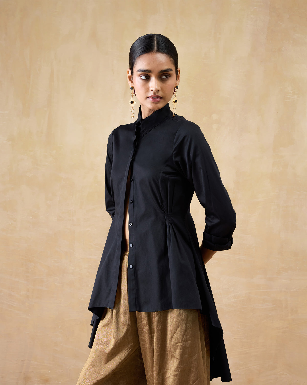 Side view of a black Rai top showing the cinched waist and longer back hem.