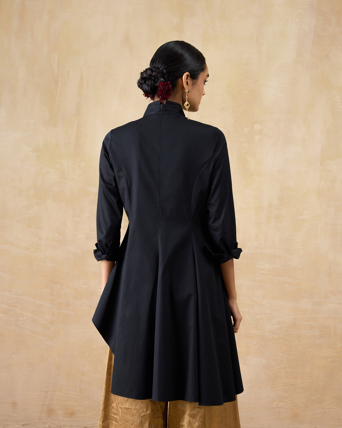 Back of a black Rai top showing the flared asymmetrical hem.