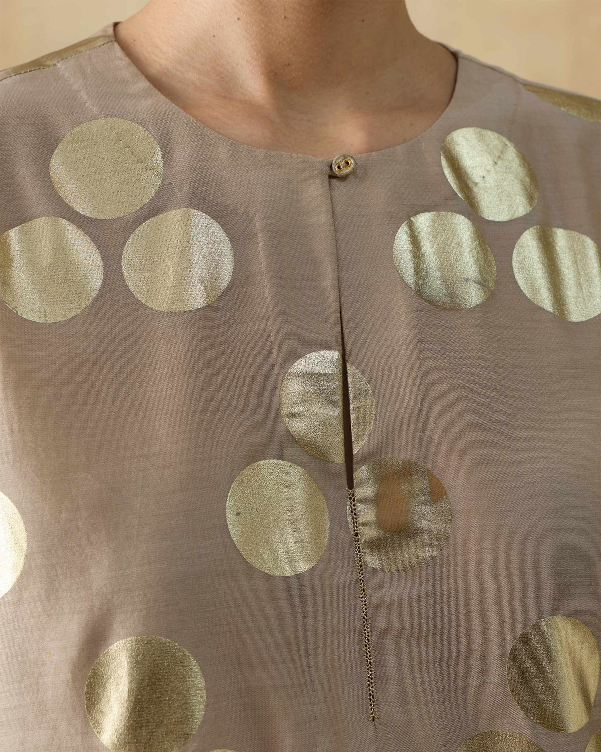 Close-up of a sand Cloud Dancer kurta neckline with gold foil dots.