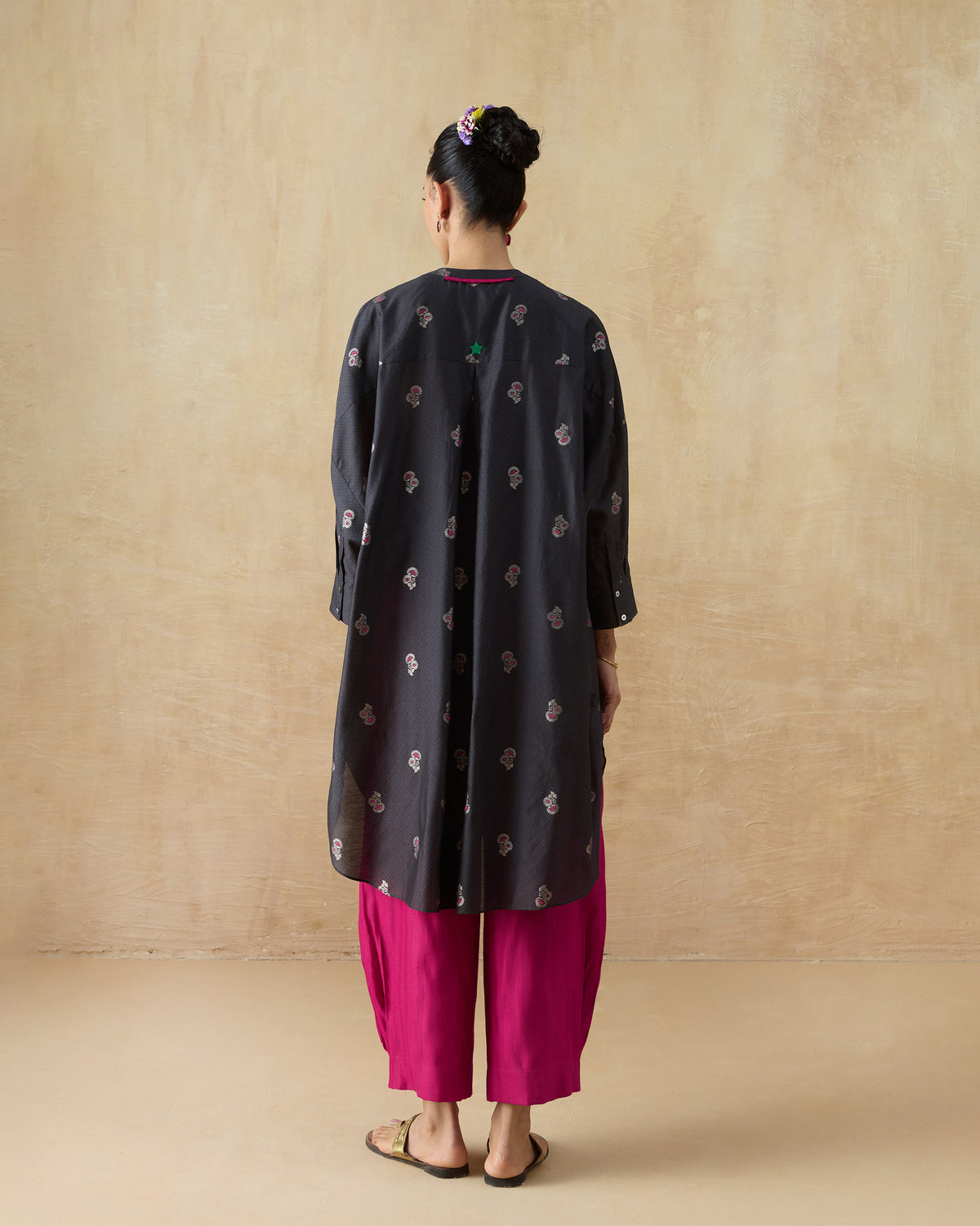 Back of a charcoal Lazy Sunday tunic with pink florals and a green embroidered back motif.