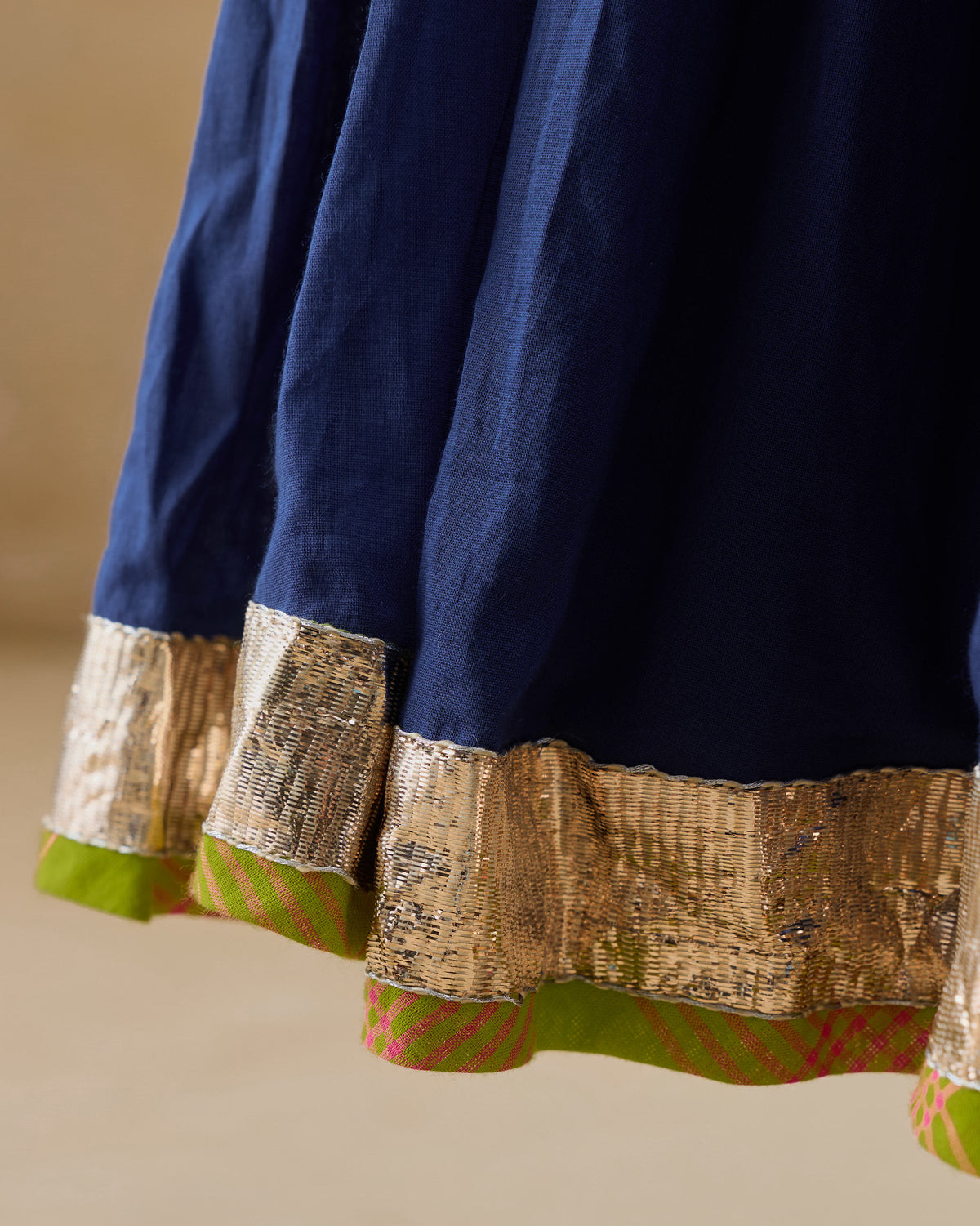 Close-up of the gold and lime green hem border on the navy Kochi kurta.
