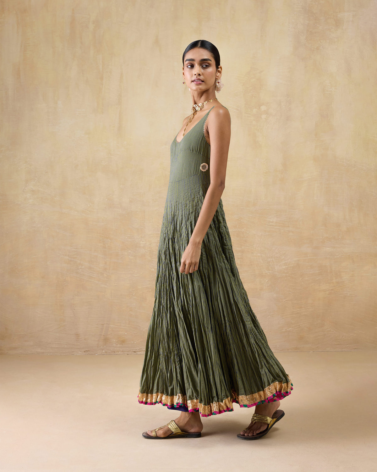 Person wearing a purple-and-lime check Kochi kurta with a gold hem and pink tassels.