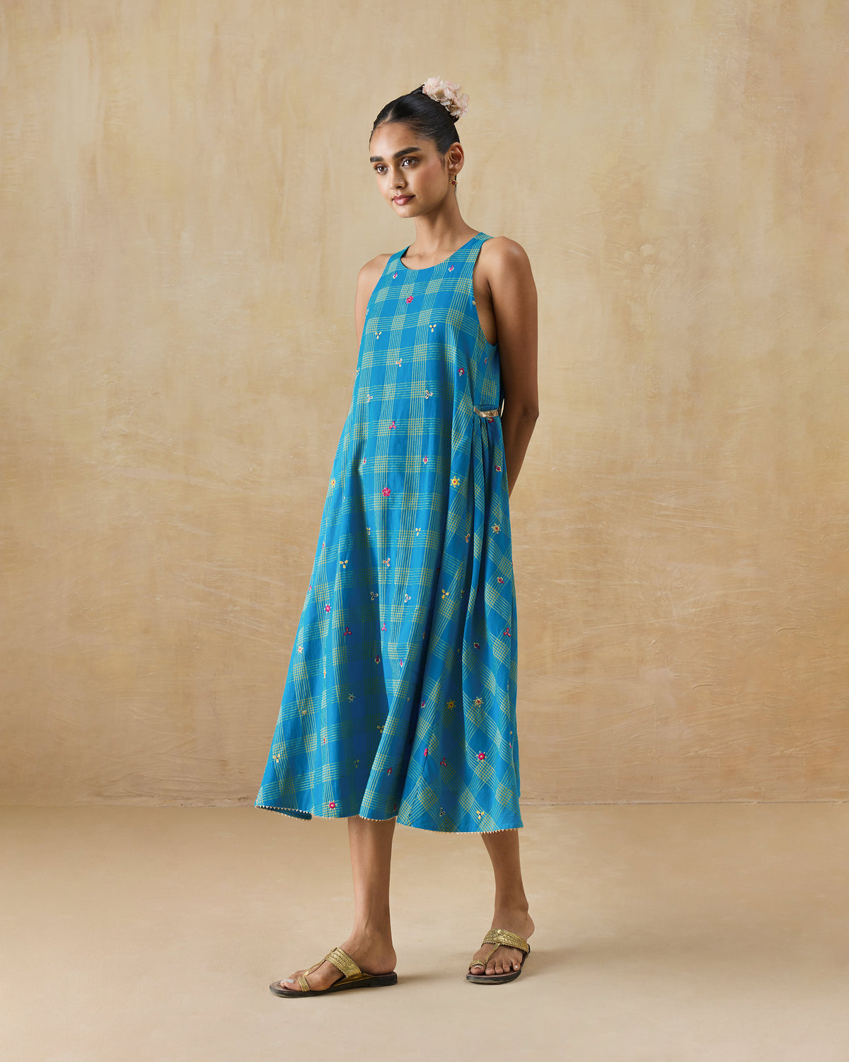 Person wearing a cerulean and yellow check Nimbus dress with floral embroidery.