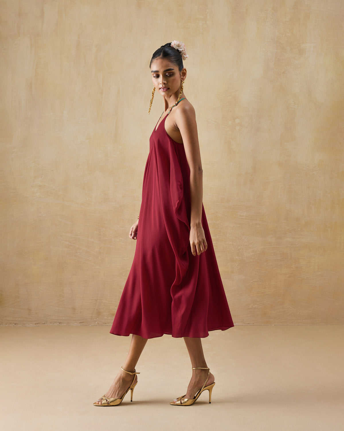 Side view of a wine red Savni dress showing the fluid midi slip silhouette.
