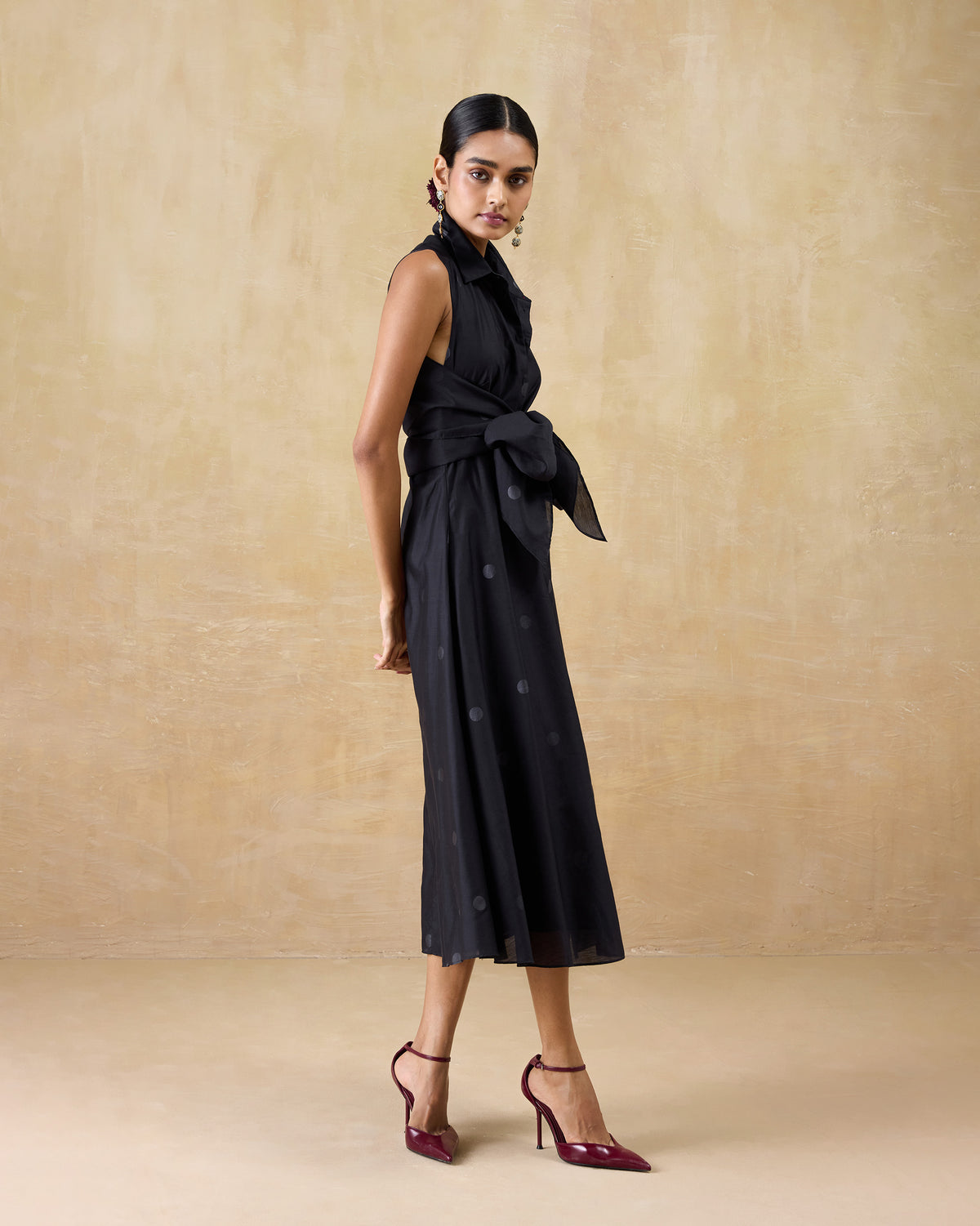 Person wearing a black Sonnet dress with a waist bow.