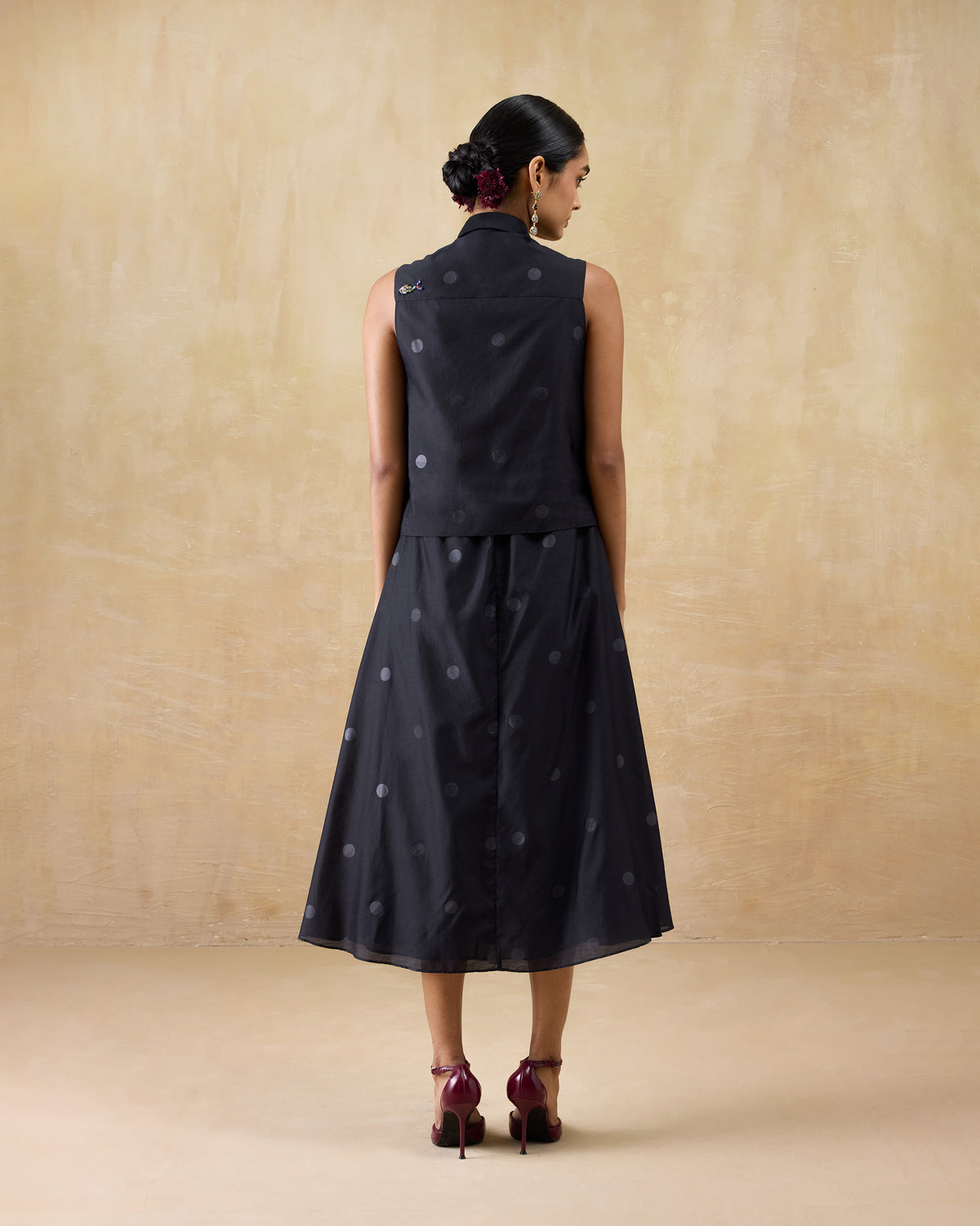 Back of a black Sonnet dress with a flared midi skirt.