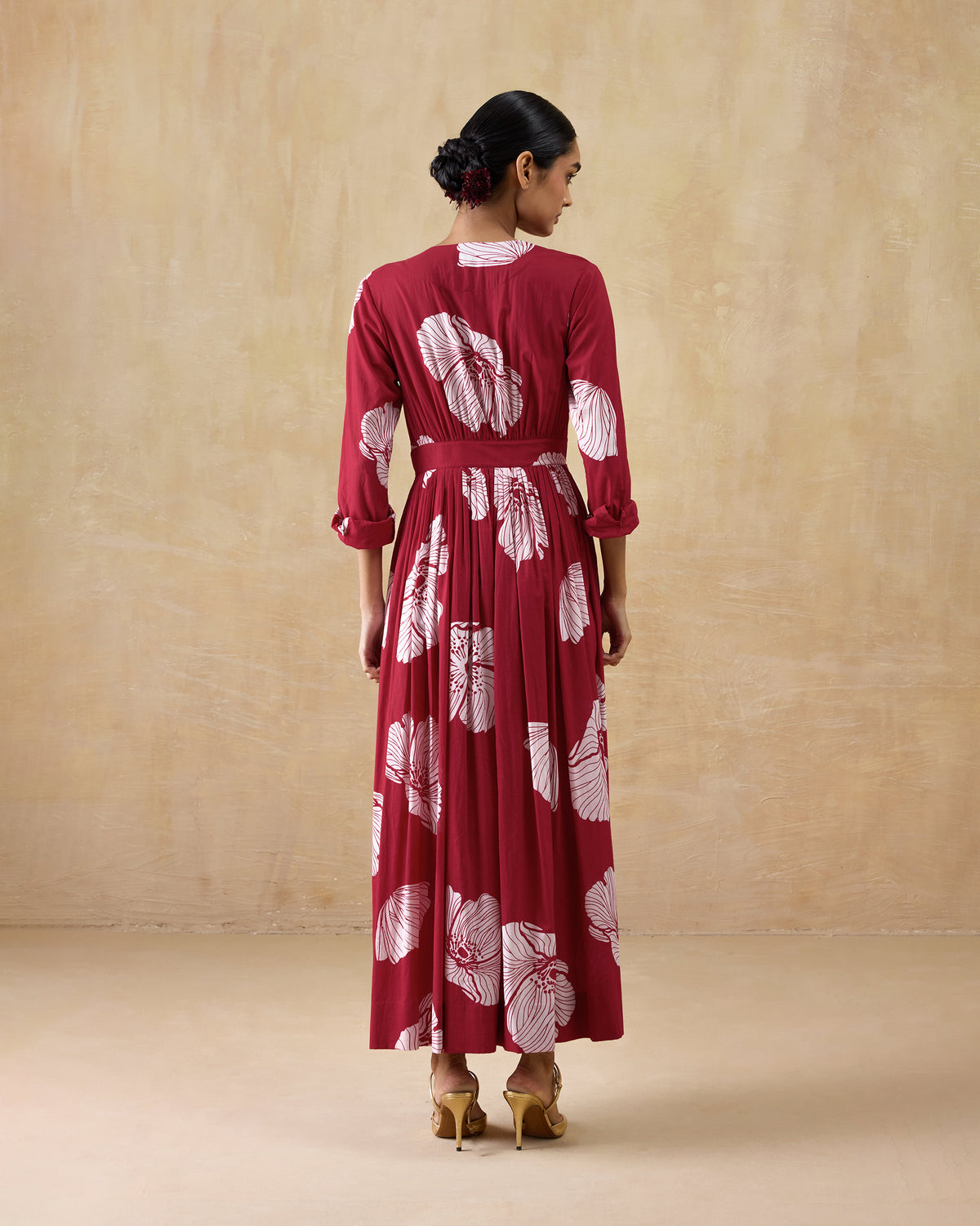 Back of a red and ivory Nico dress showing the gathered waist and flowing maxi skirt.