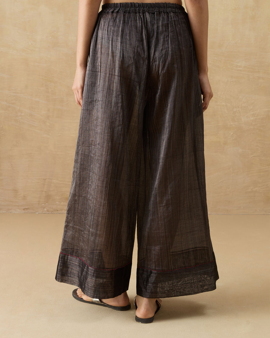 Back view of the Charisma Pants in black metallic tissue, showing the deep hem band.