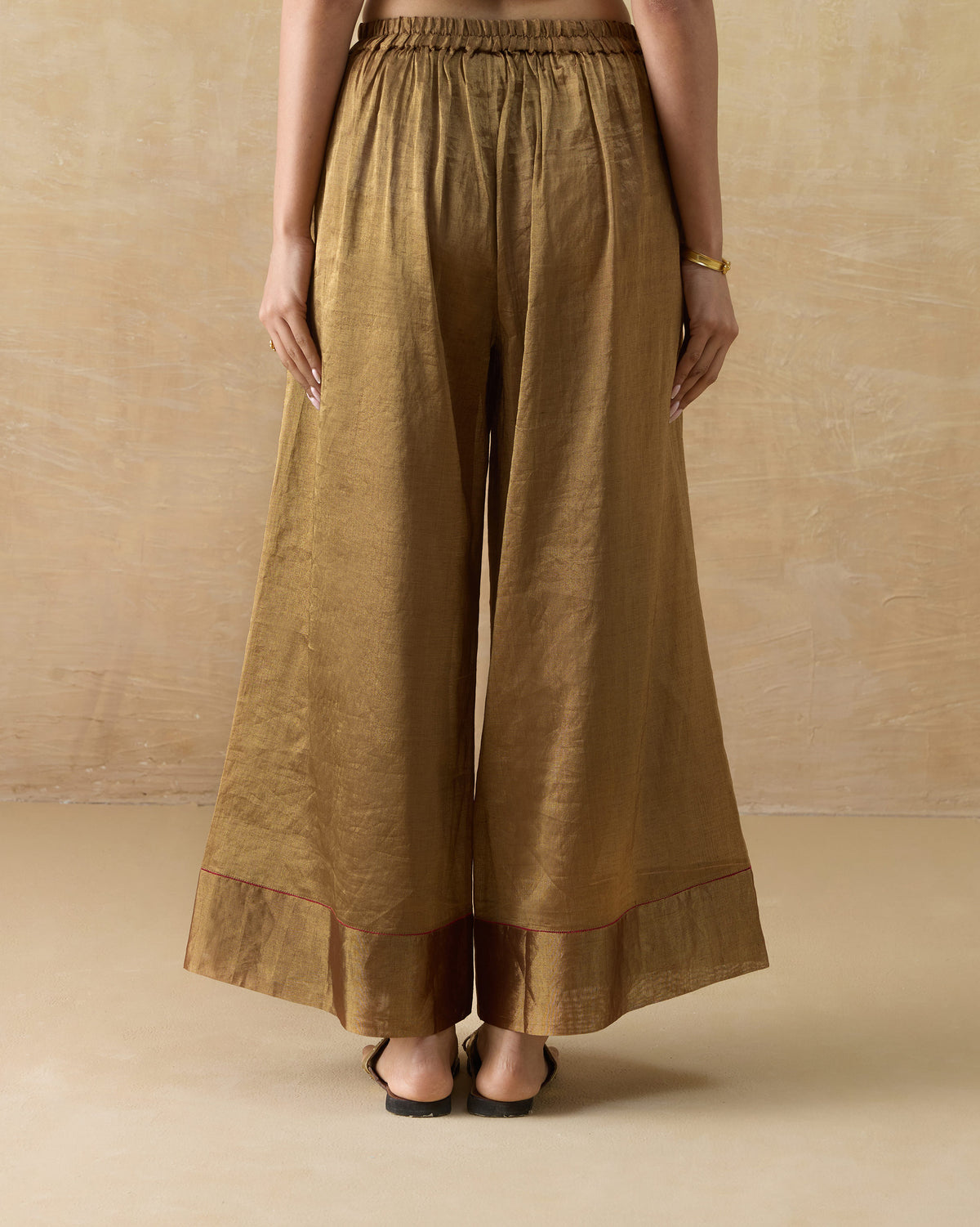 Back of gold metallic Charisma pants with a gathered elastic waist.
