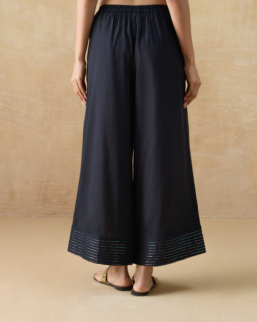 Back view of the Stellar Pants, showing the sequin pintucked hem panel.