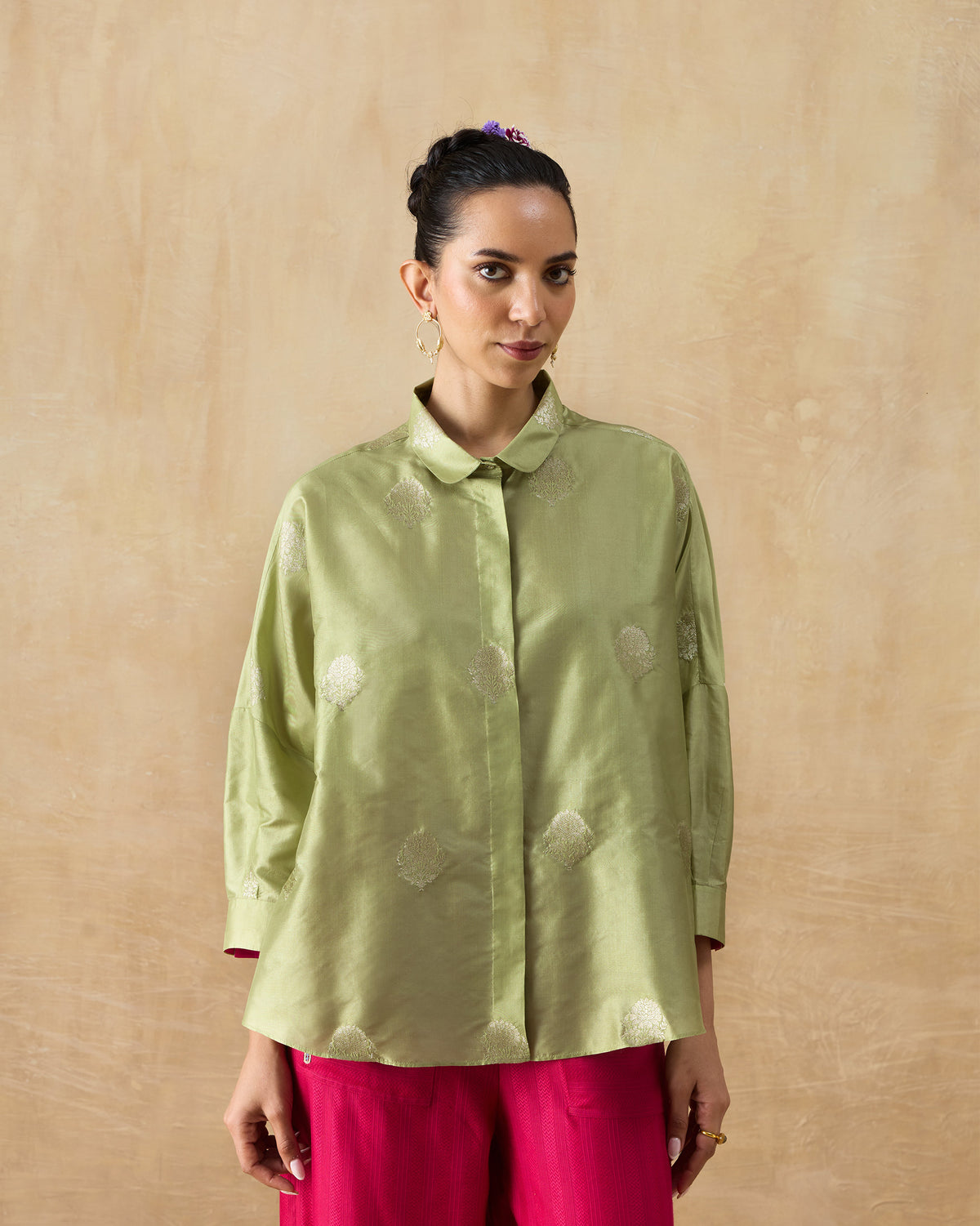 Person wearing a leaf green Boxy shirt with a loose silk blend fit.