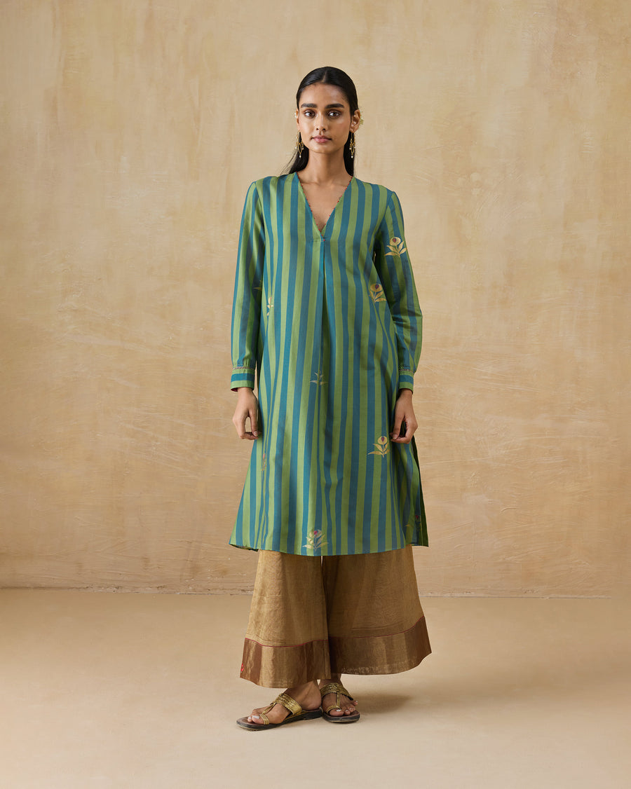 The Front Pleated Kurta worn over gold Charisma Pants with flat sandals.