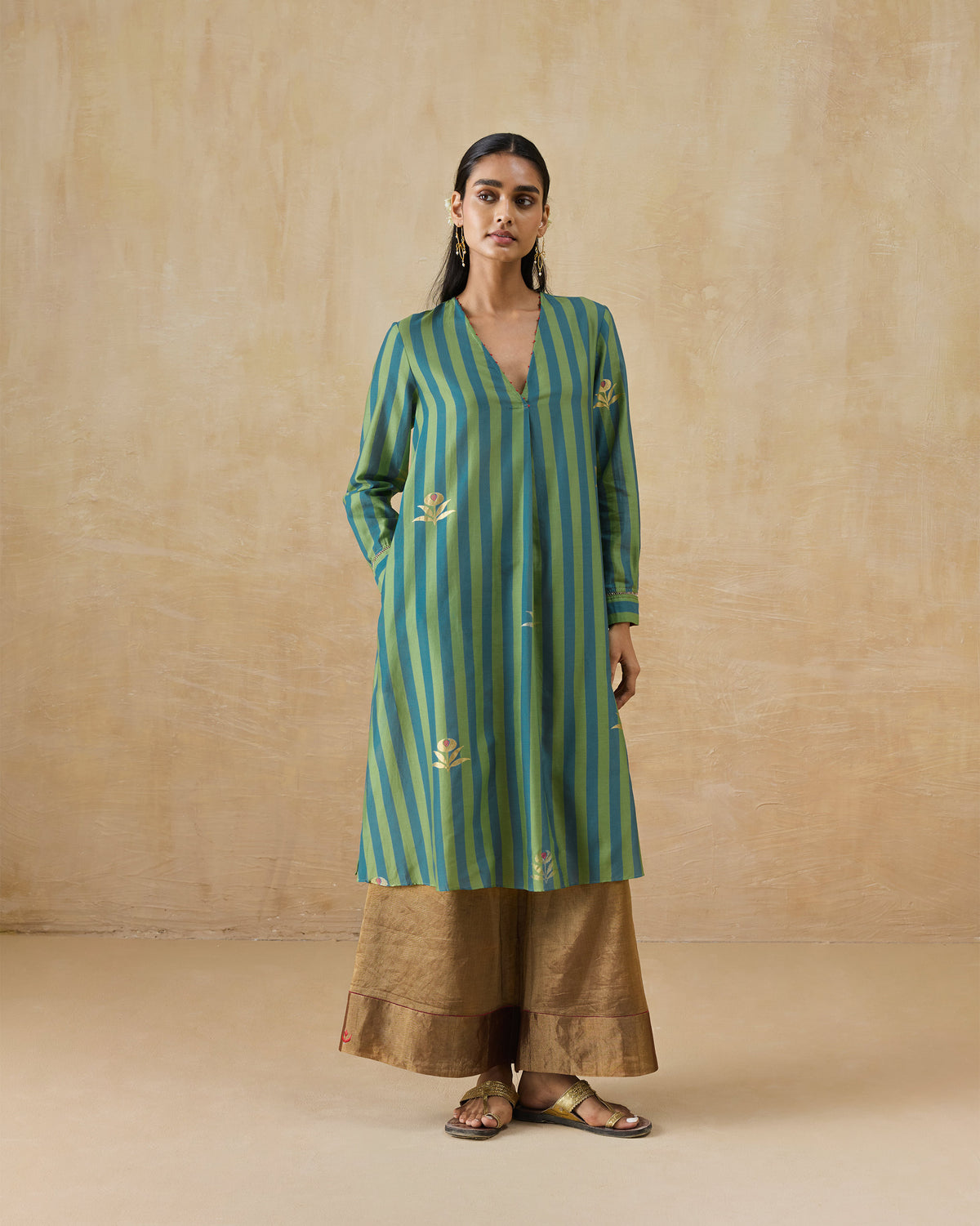 Person wearing a green and blue striped Front Pleated kurta with gold embroidery.