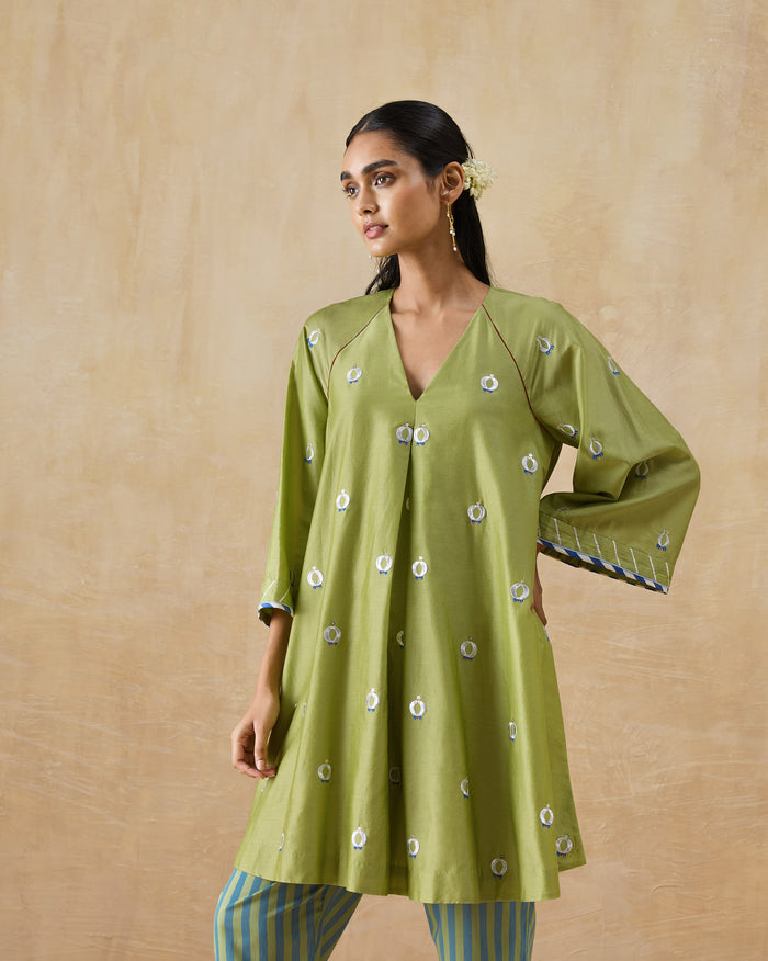 Person wearing an olive green Revelry kurta with white and blue motifs.