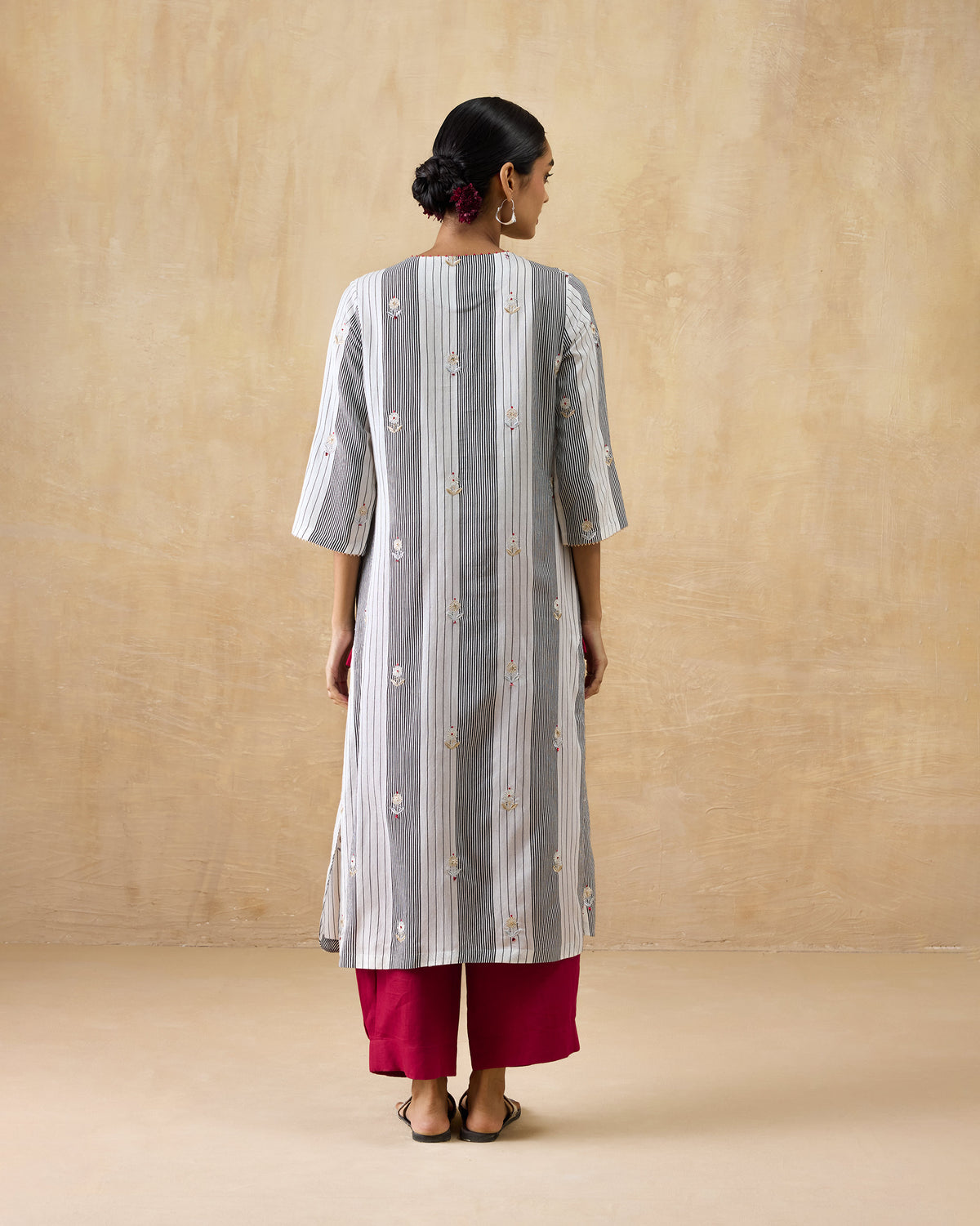 Back of a black and ivory striped Dash Kurta with floral embroidery.