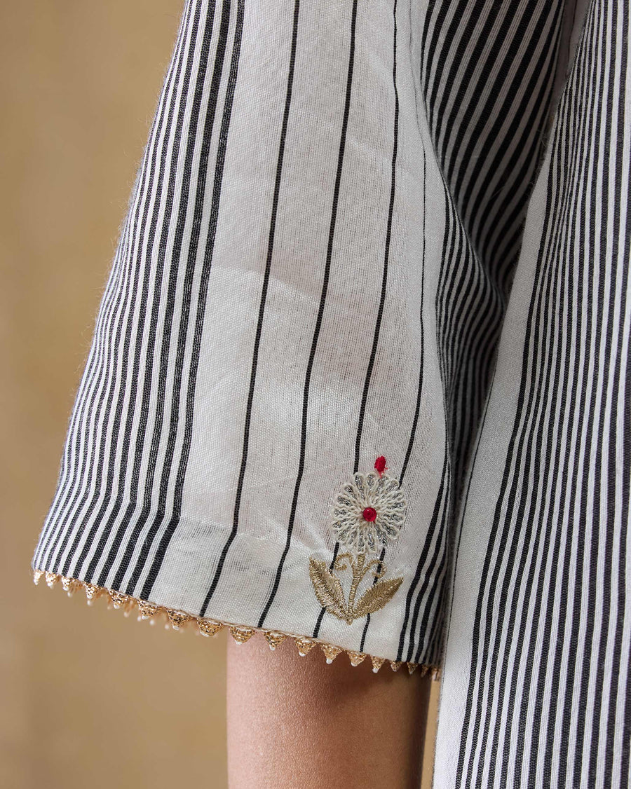Close-up of the sleeve hem of the Dash Kurta, with gold samosa gota and an embroidered gota flower.