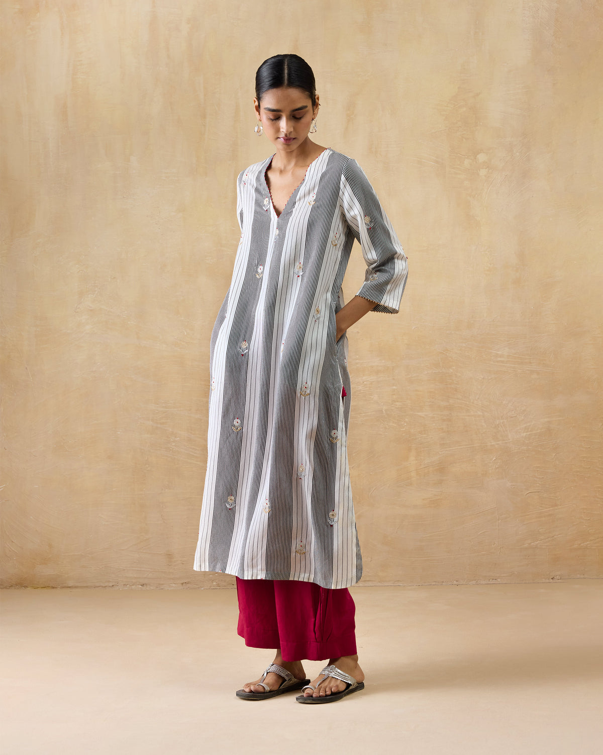 Person wearing a black and ivory striped Dash Kurta with floral embroidery.