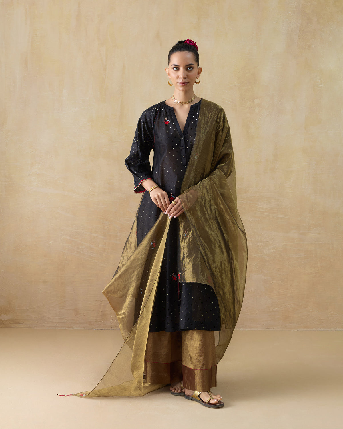 Person wearing a black Moonbeam kurta with gold dots and floral embroidery.