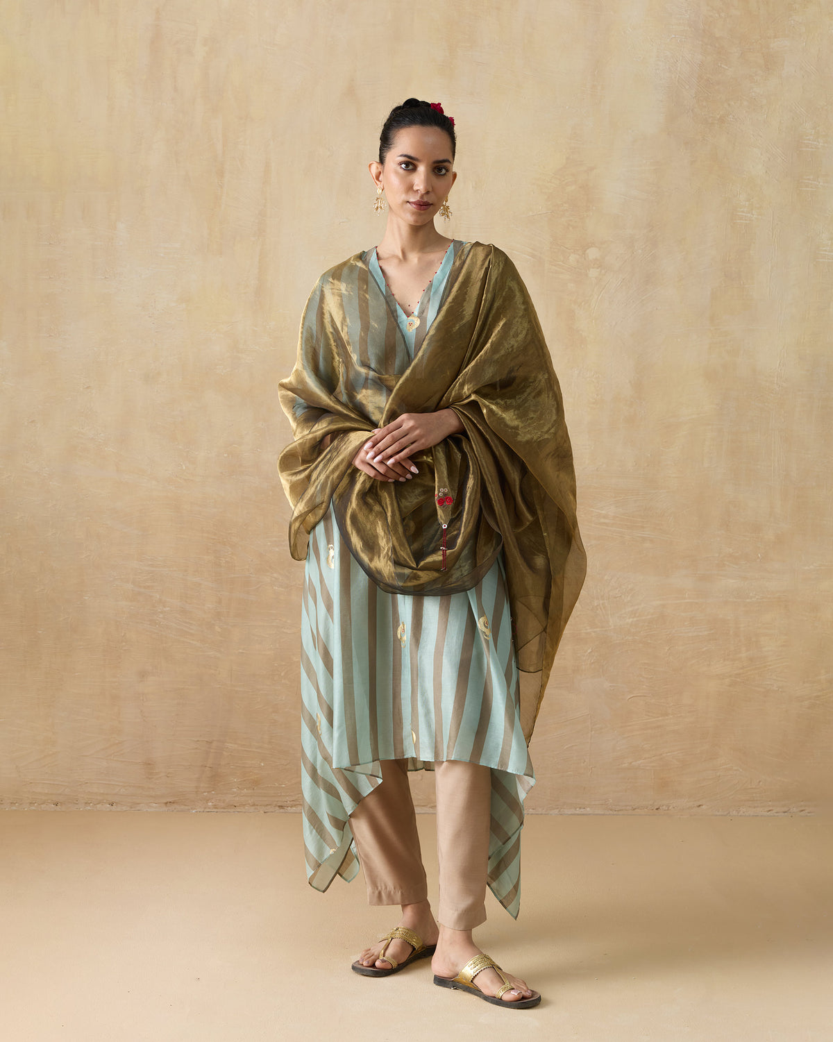 Person wearing a grey and aqua striped Midnight Club kurta with gold motifs.
