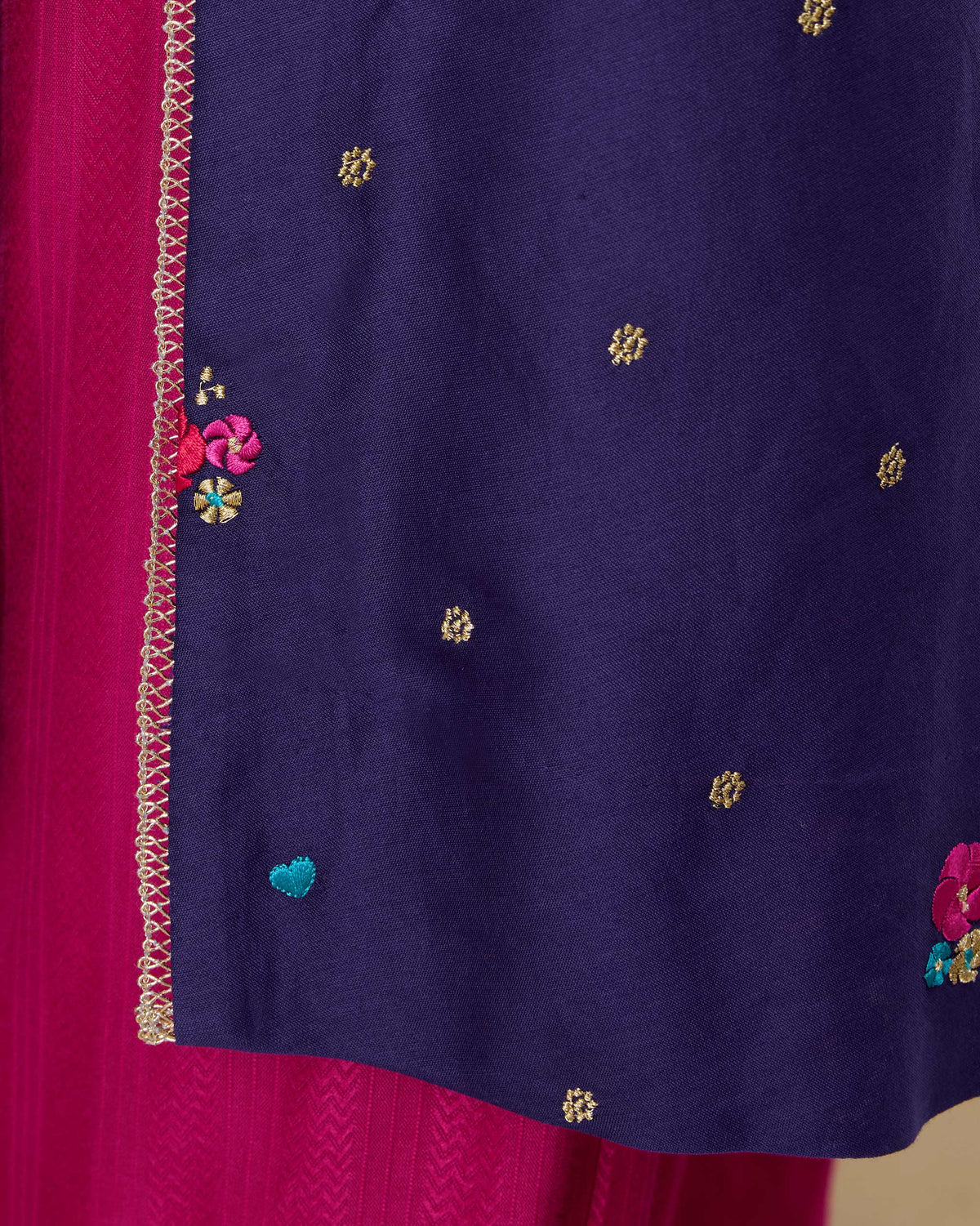 Close-up of gold trim and a turquoise heart on a purple Nebula kurta.