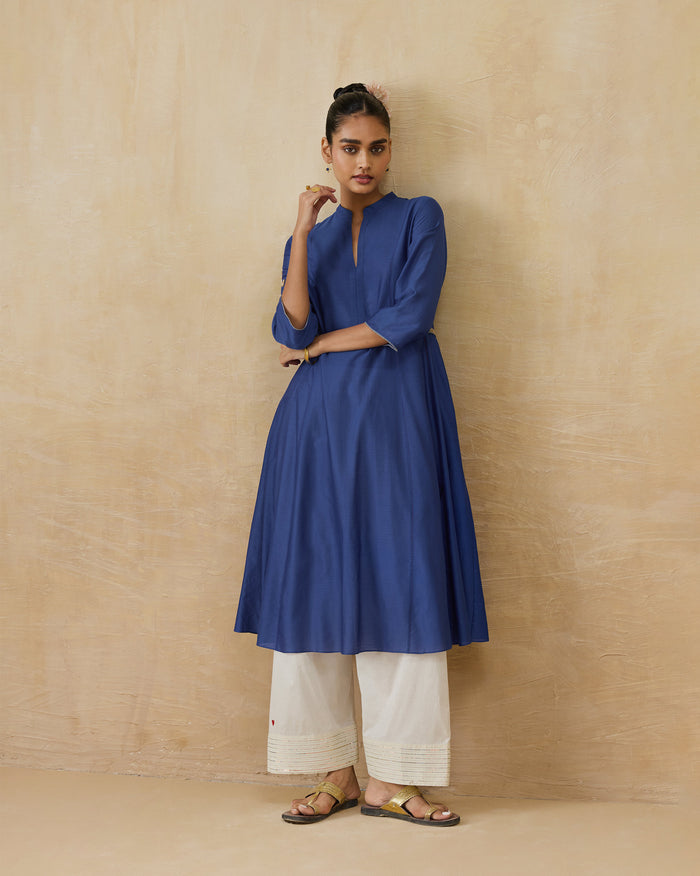Person wearing a cobalt Moonsong kurta with an A-line flare.