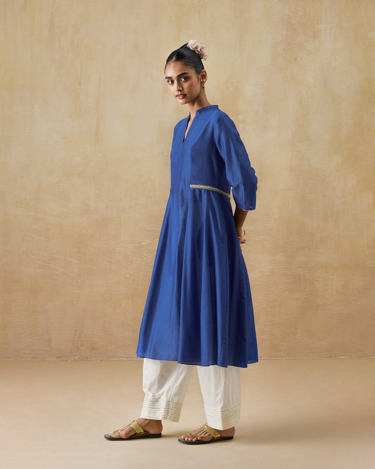 Side view of a cobalt Moonsong kurta with a gold waist trim.