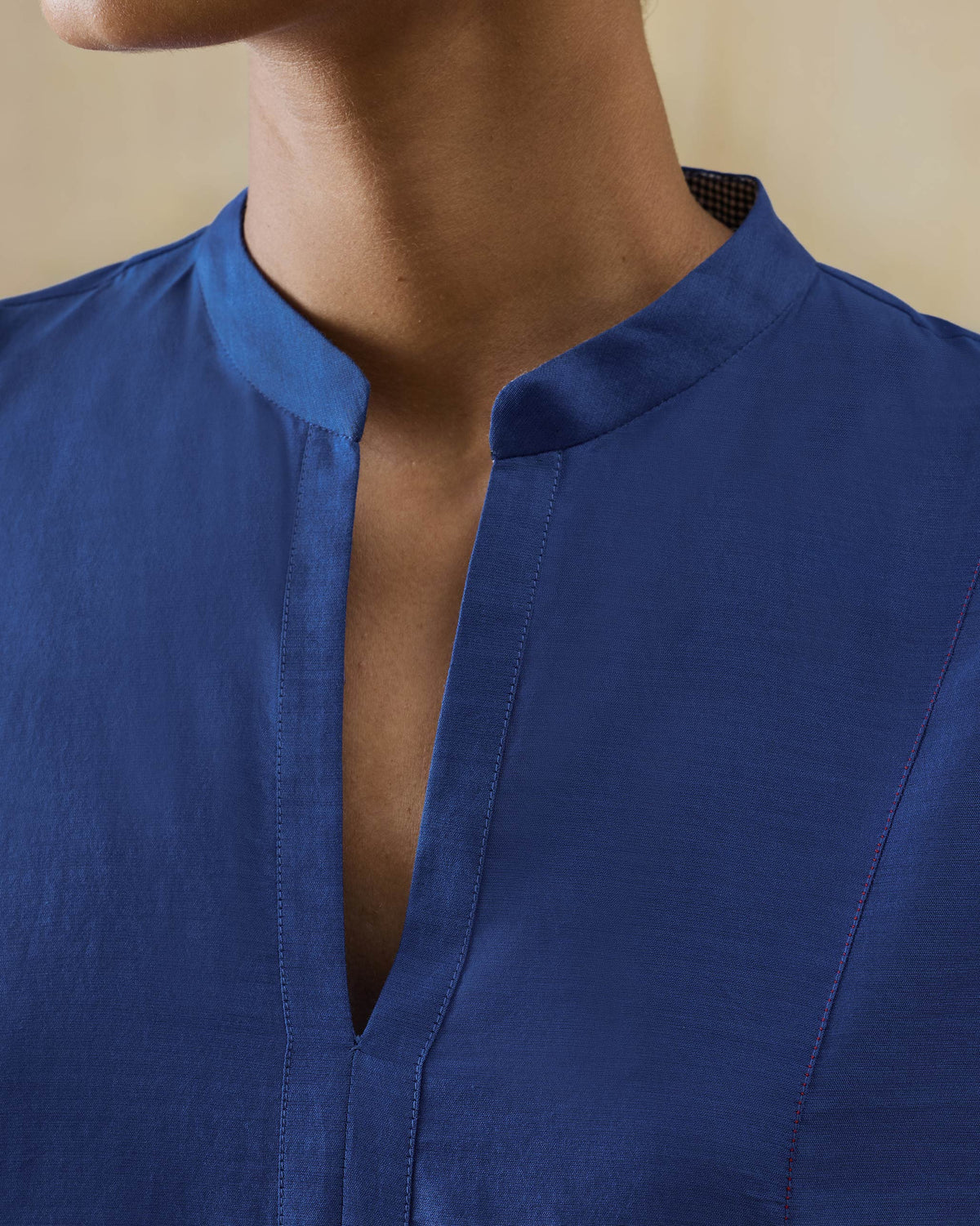 Close-up of a cobalt Moonsong kurta mandarin collar with a deep V opening.