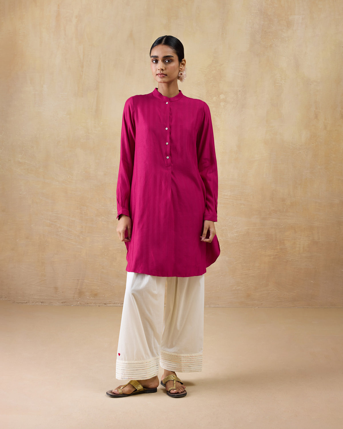 Person wearing a berry pink mid-length kurta with a button placket.