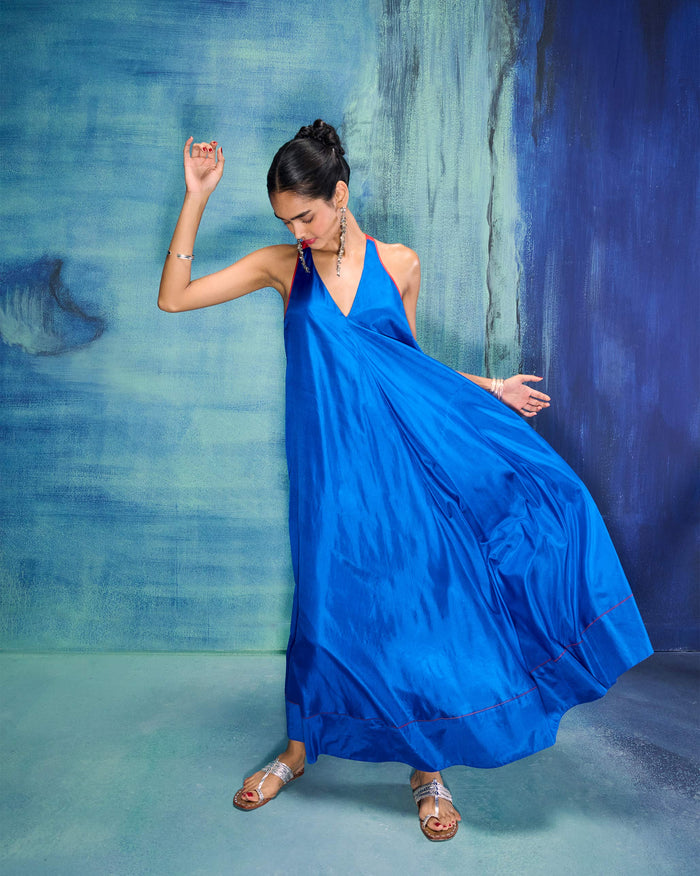 Person wearing a cobalt blue Akira Twist Back Dress with red trim.