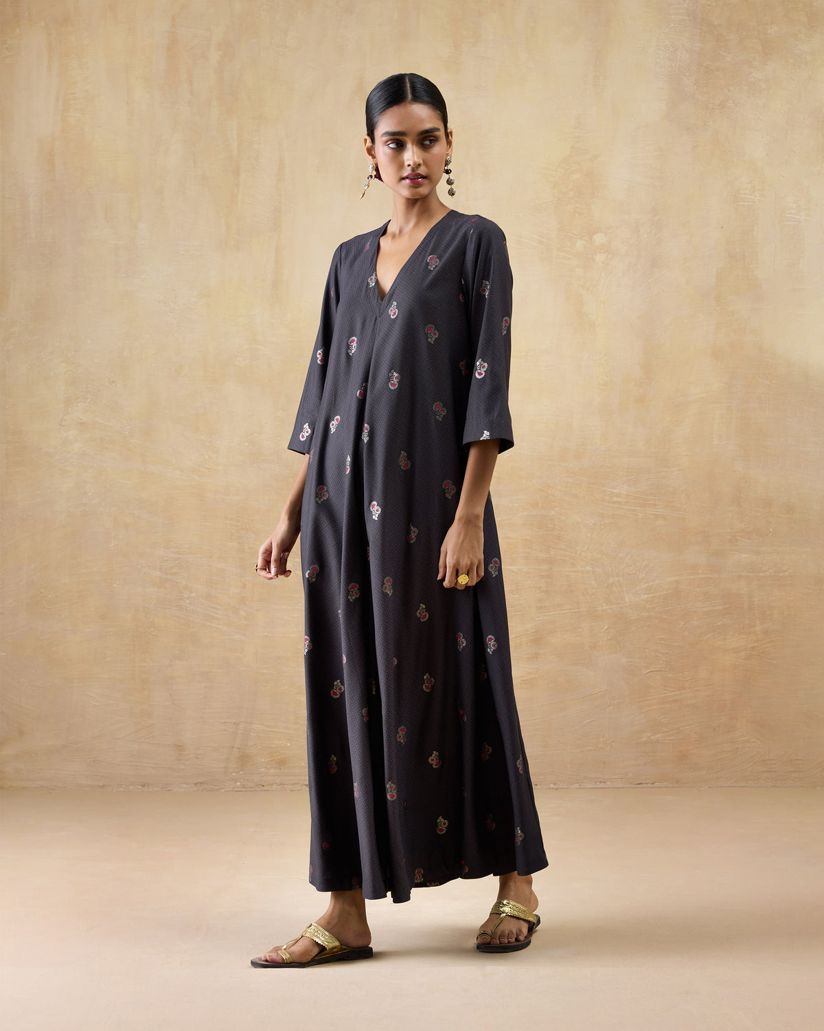 Person wearing a charcoal Bash jumpsuit with pink floral print.