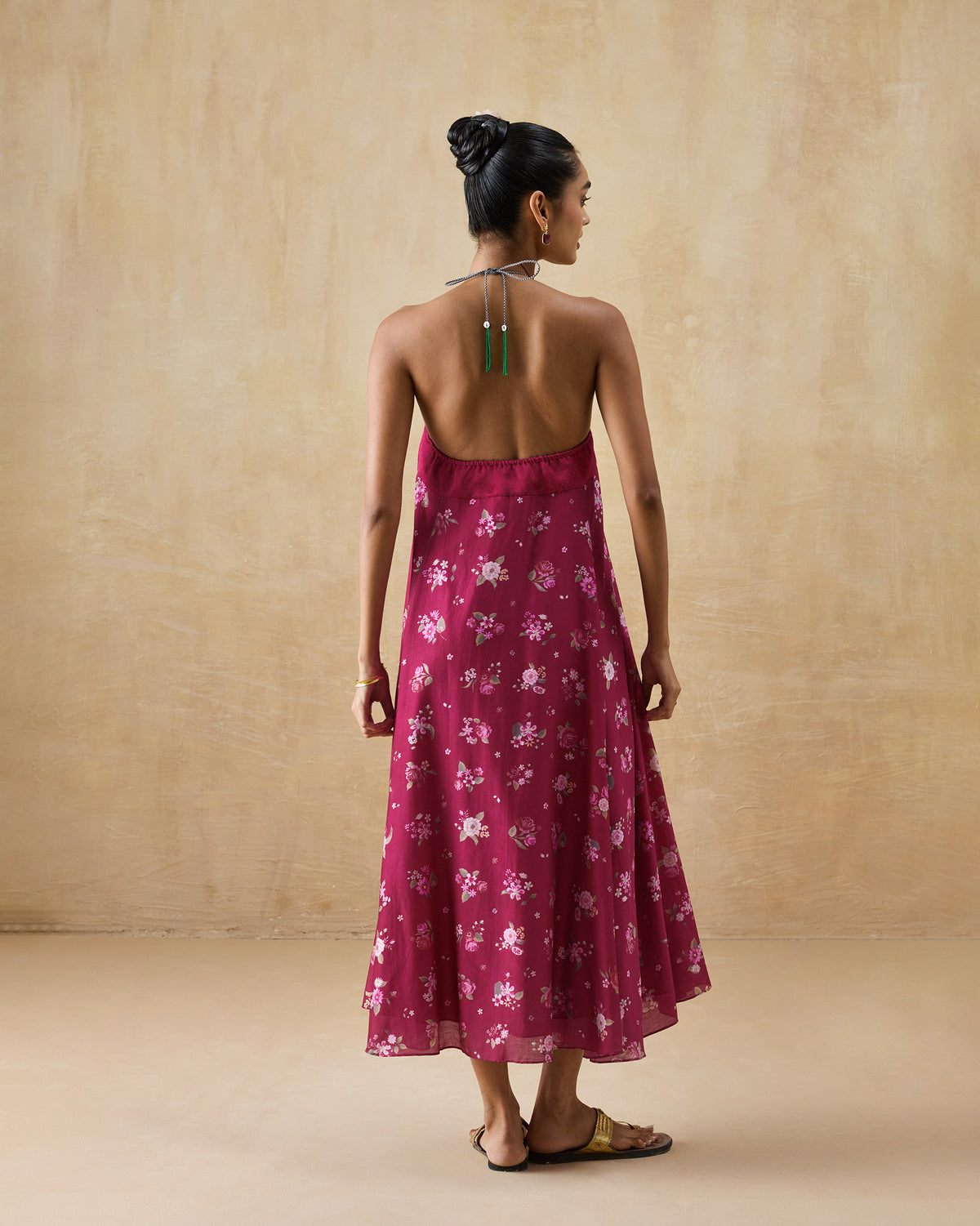 Back of a berry floral Lumen dress with green tassel neck ties.