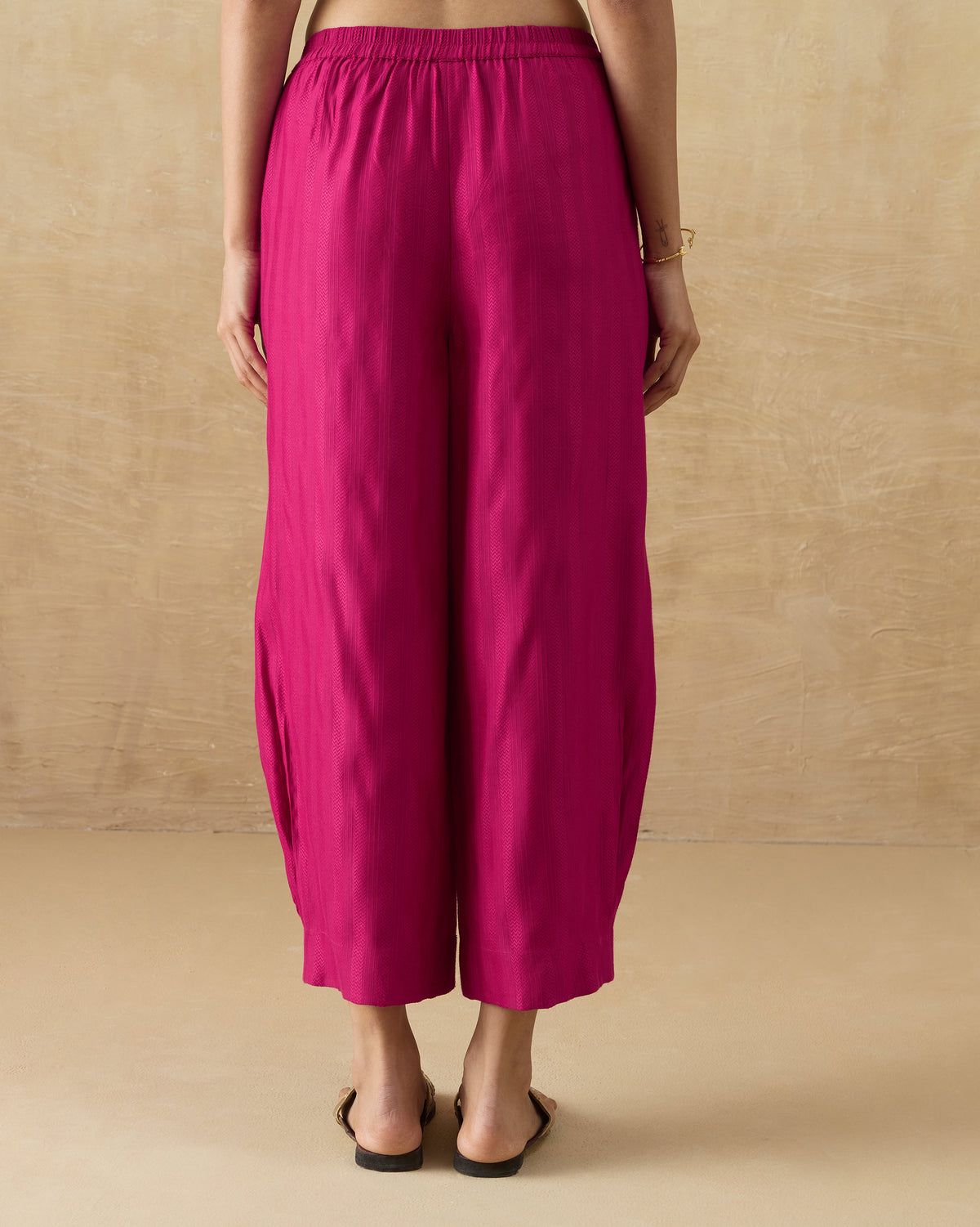 Back of berry Serene pants with a gathered waist and wide legs.