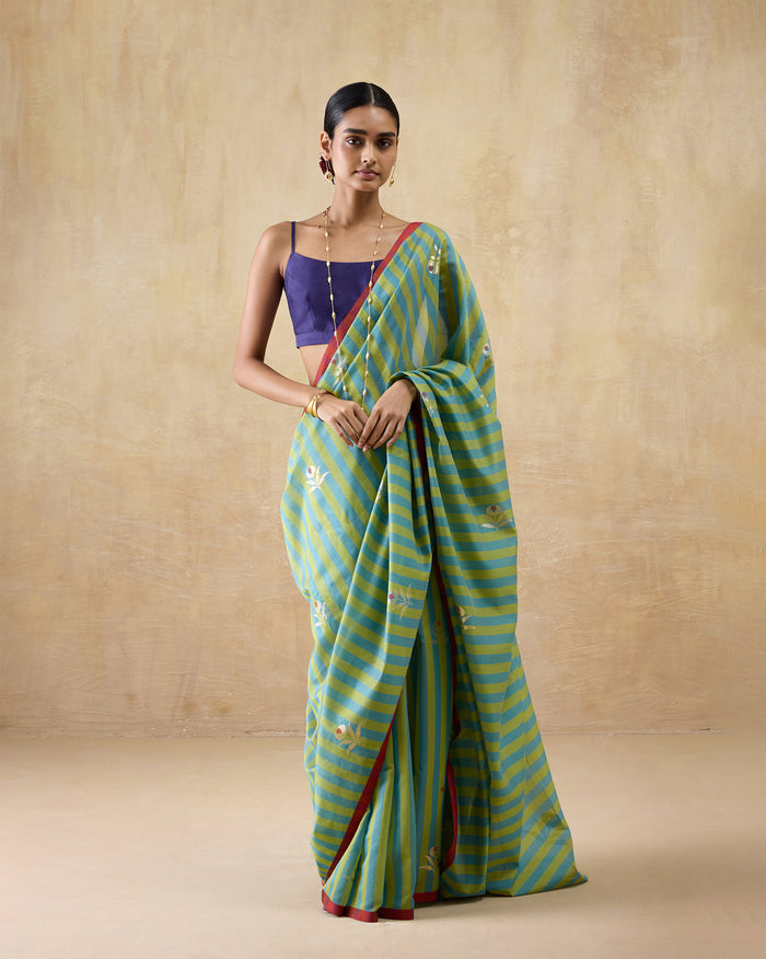 Person wearing a leaf green and teal striped Garden Party Sari with floral motifs.