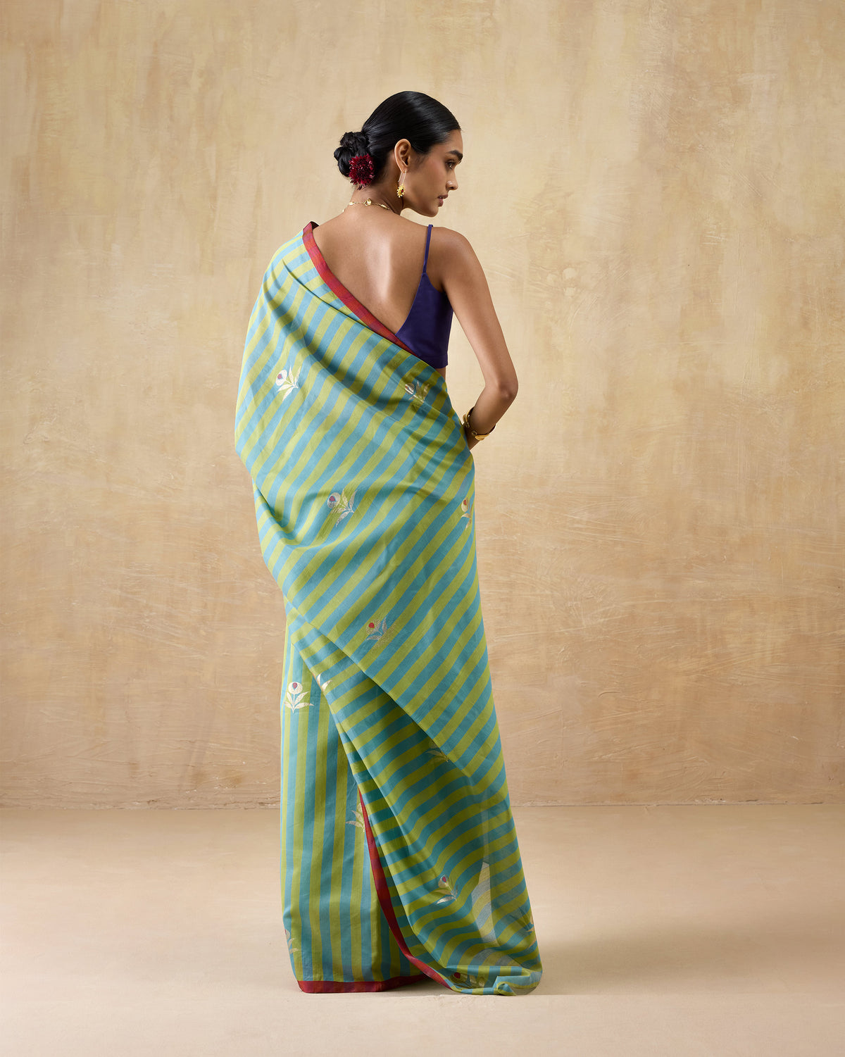 Back of a leaf green and teal striped Garden Party Sari with floral motifs.