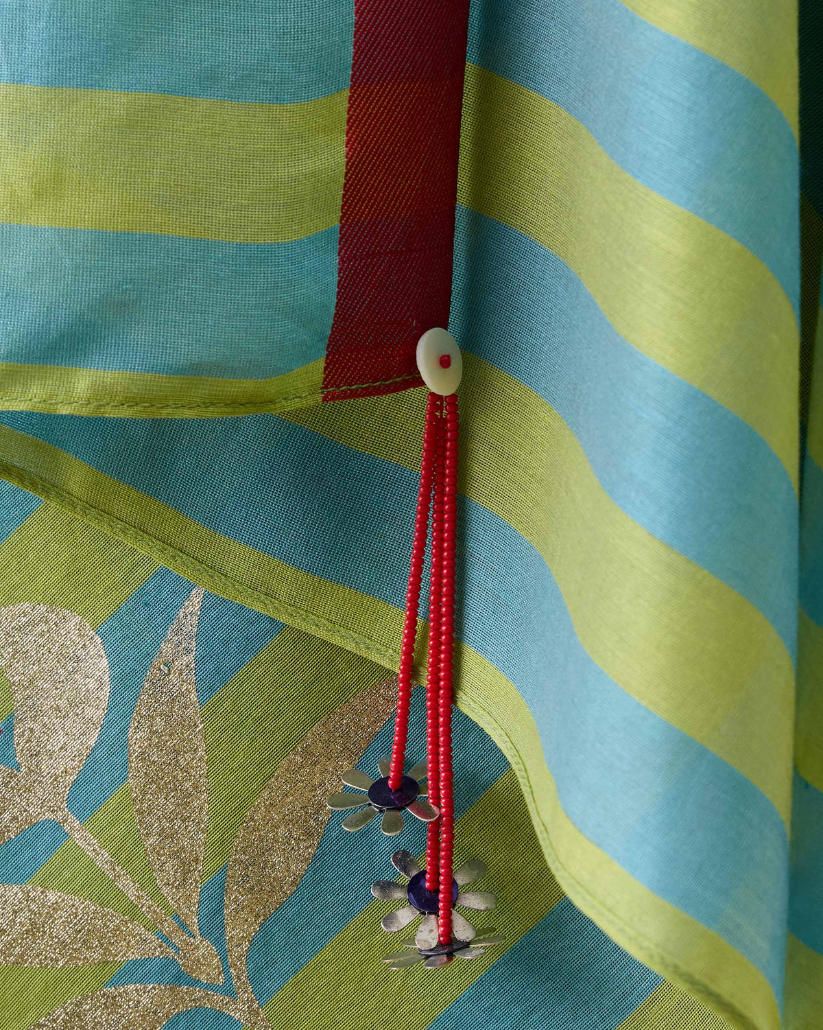 Close-up of Garden Party Sari red border with beaded flower tassels.