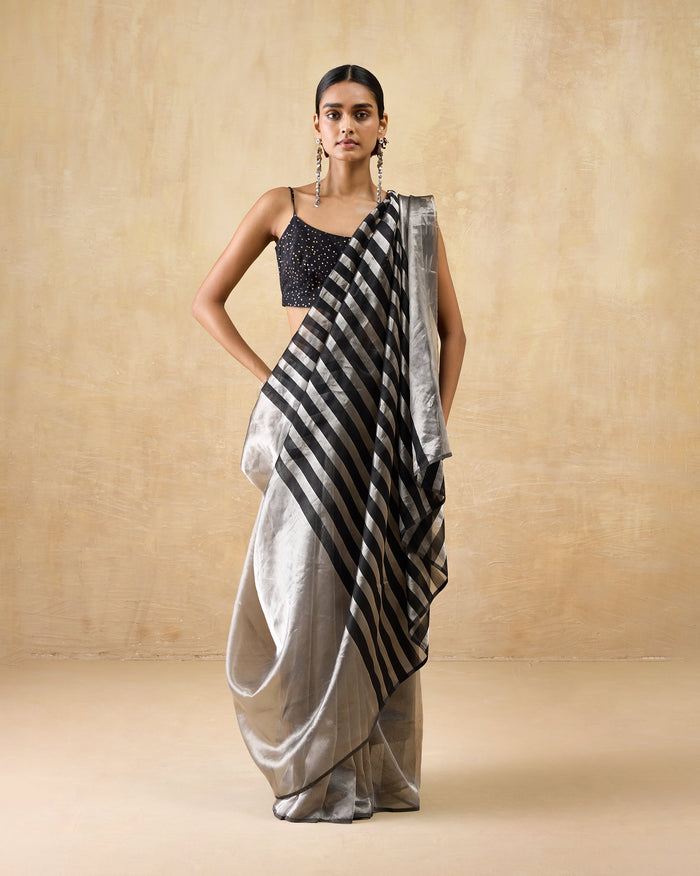 Person wearing a silver Party Stripes sari with a black striped pallu.