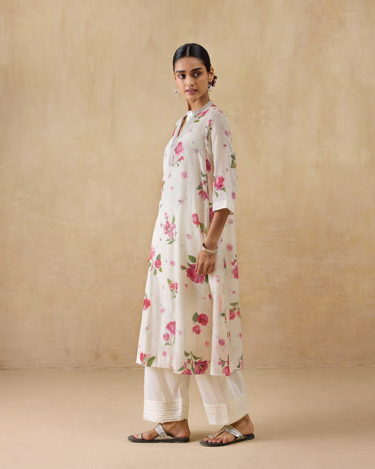 Person wearing an ivory kurta with a pink rose print.