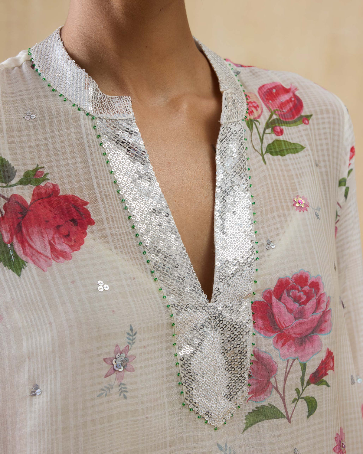 Close-up of an ivory rose-print kurta with a sequined V-neck.
