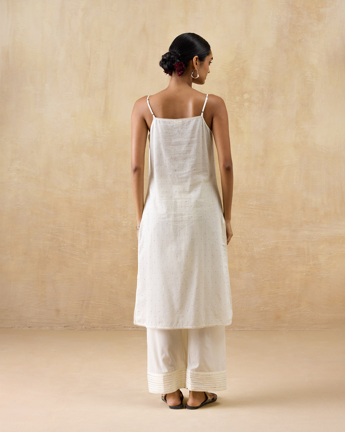 Back of a white sleeveless slip with spaghetti straps.