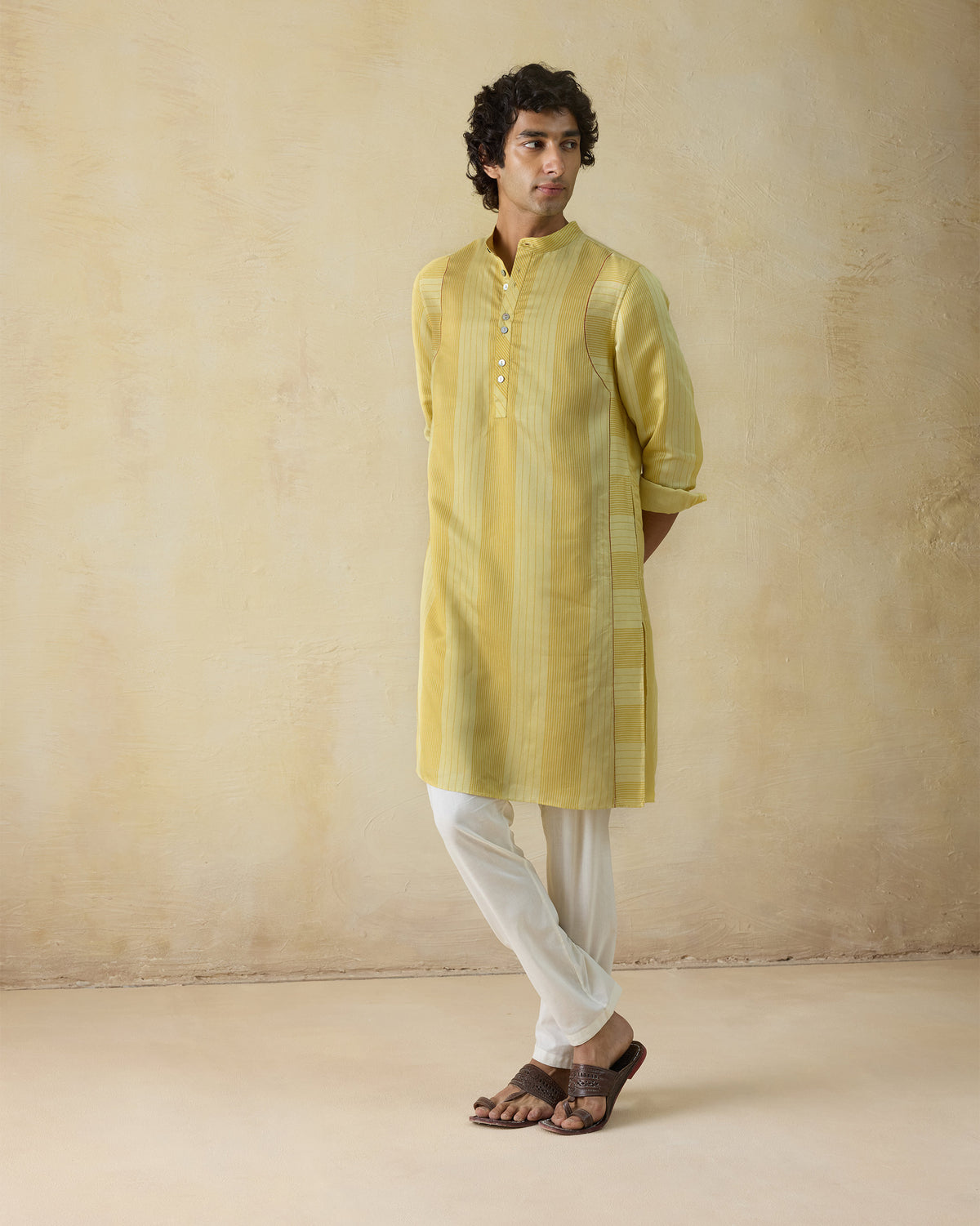 Mustard and sage striped Voyage Kurta worn full length with rolled sleeves.