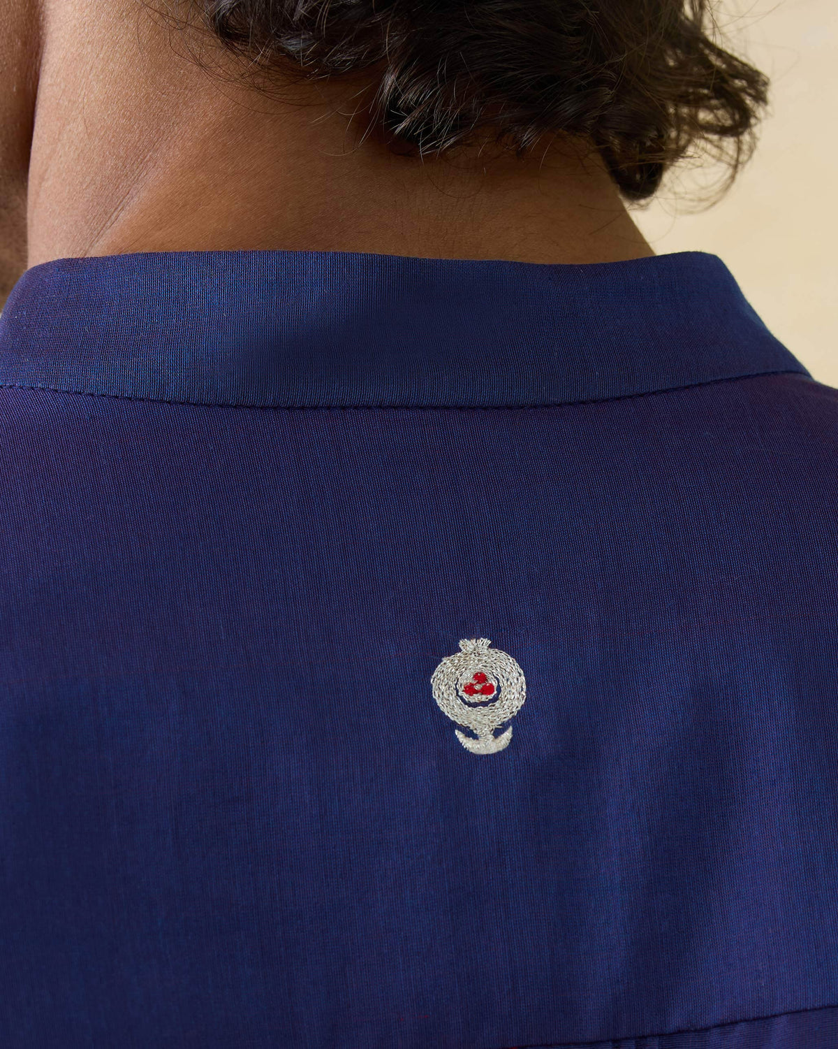 Close-up of a white motif with red dots on a dual-tone purple Naaz kurta.