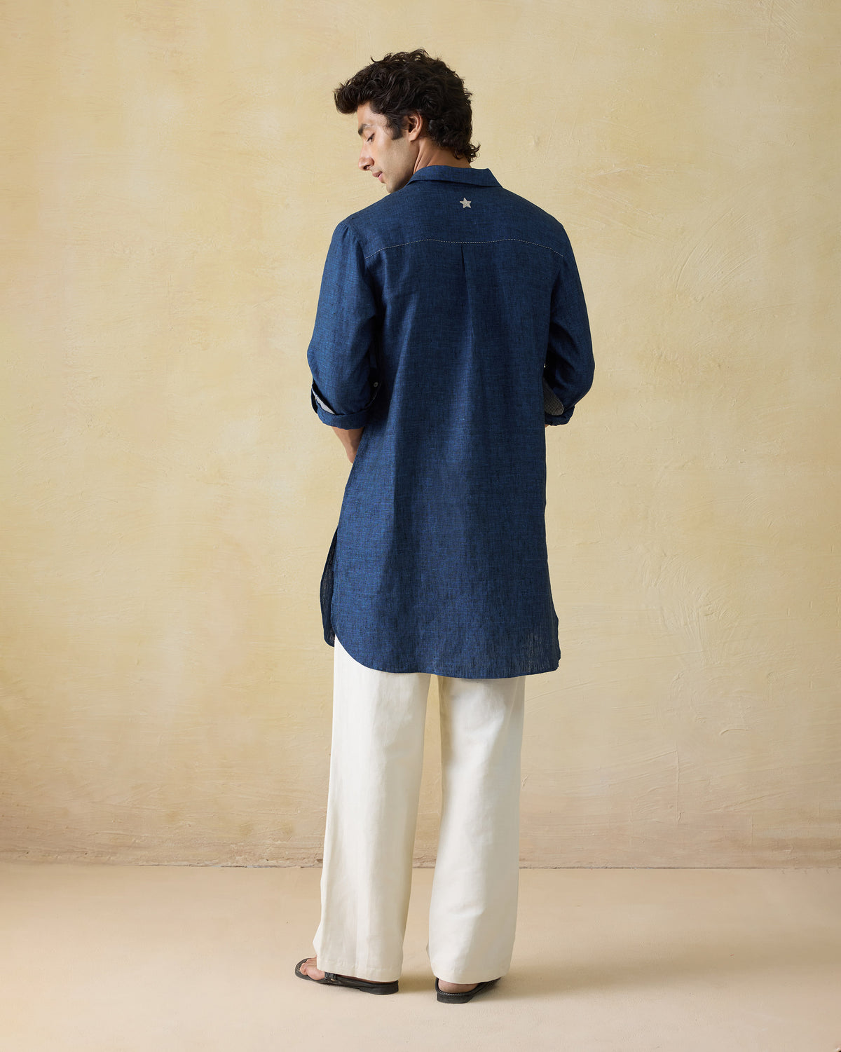 Back of a dual shaded blue Amaan linen kurta with a white star on the yoke.