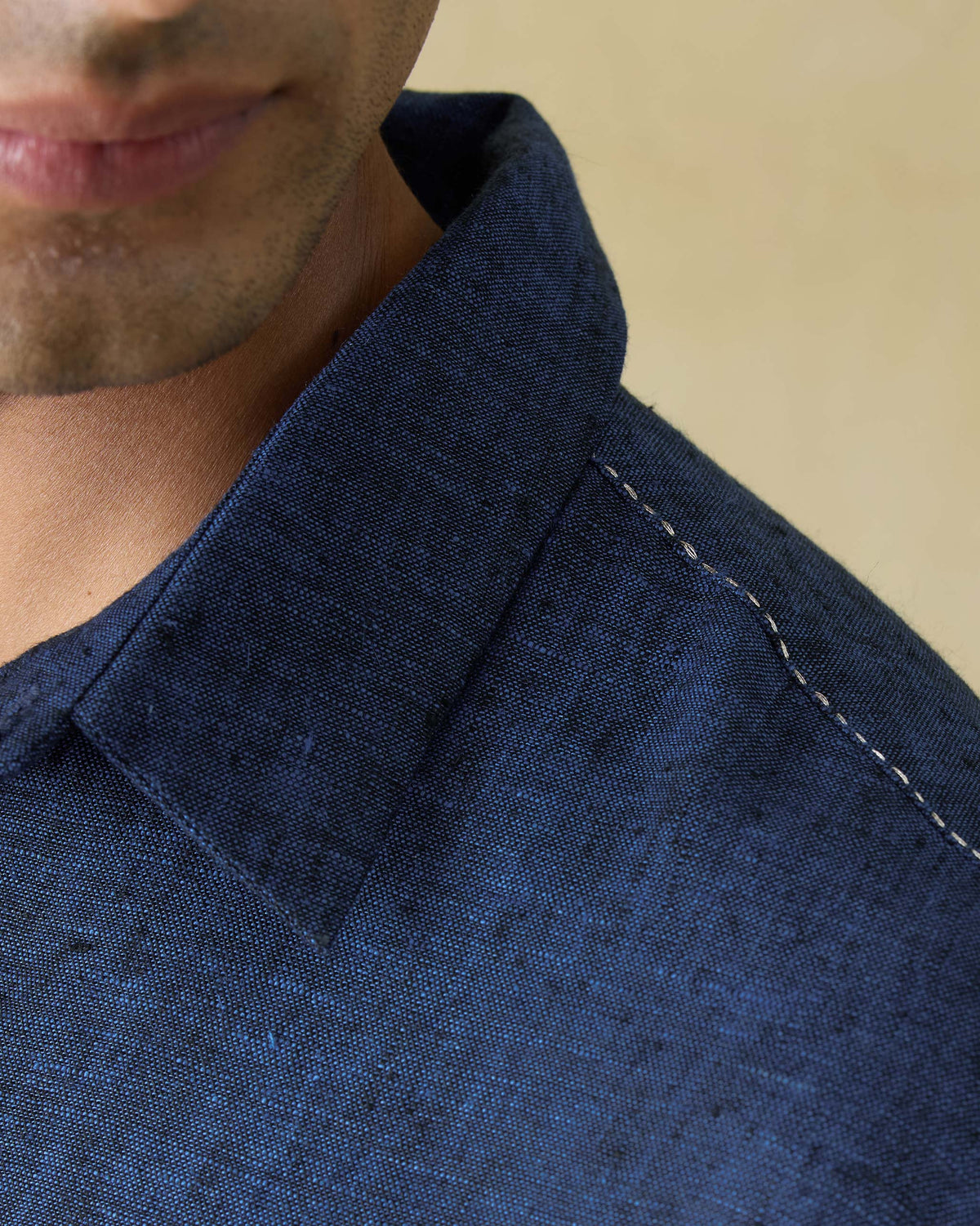 Close-up of white running stitch along the shoulder of a dual shaded blue Amaan kurta.