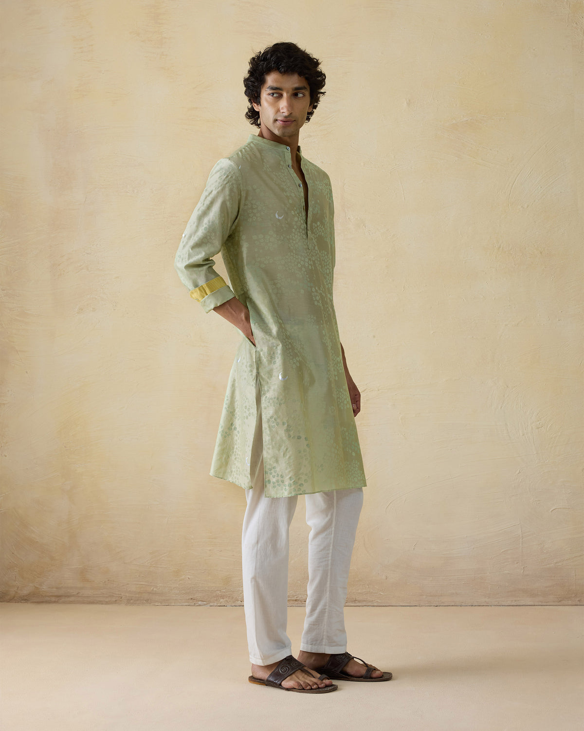 Side view of a mint green Bageecha kurta with yellow cuff lining.