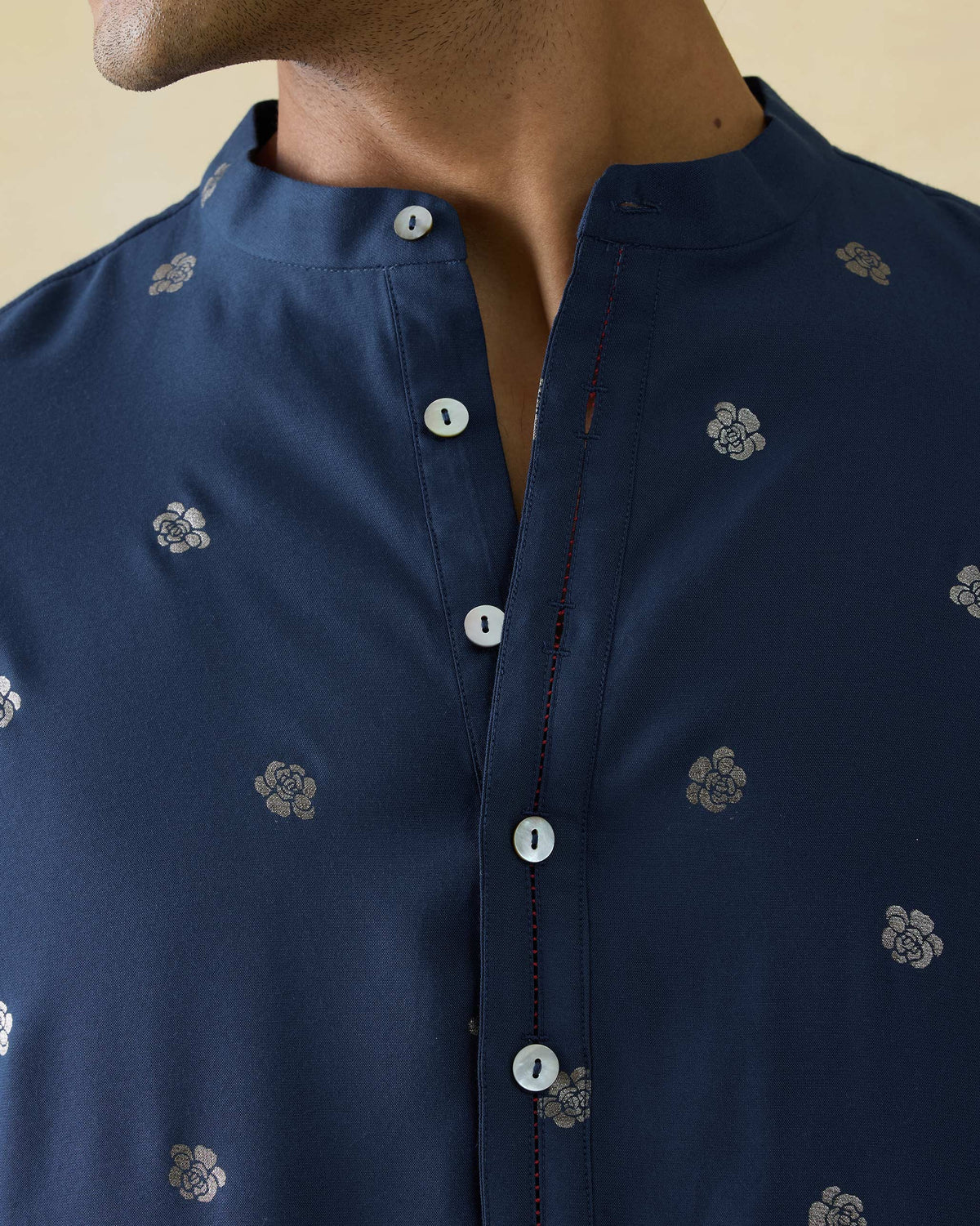 Close-up of a dark blue astral kurta placket with silver autumn bloom motifs.