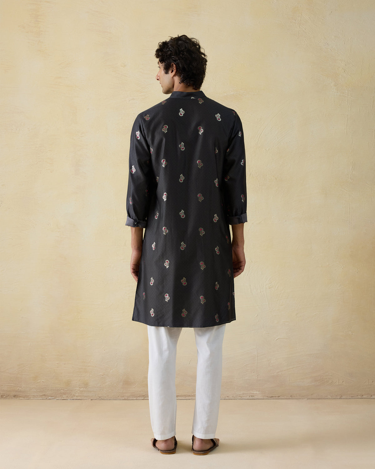 Back of a black printed Rey kurta worn by a person.