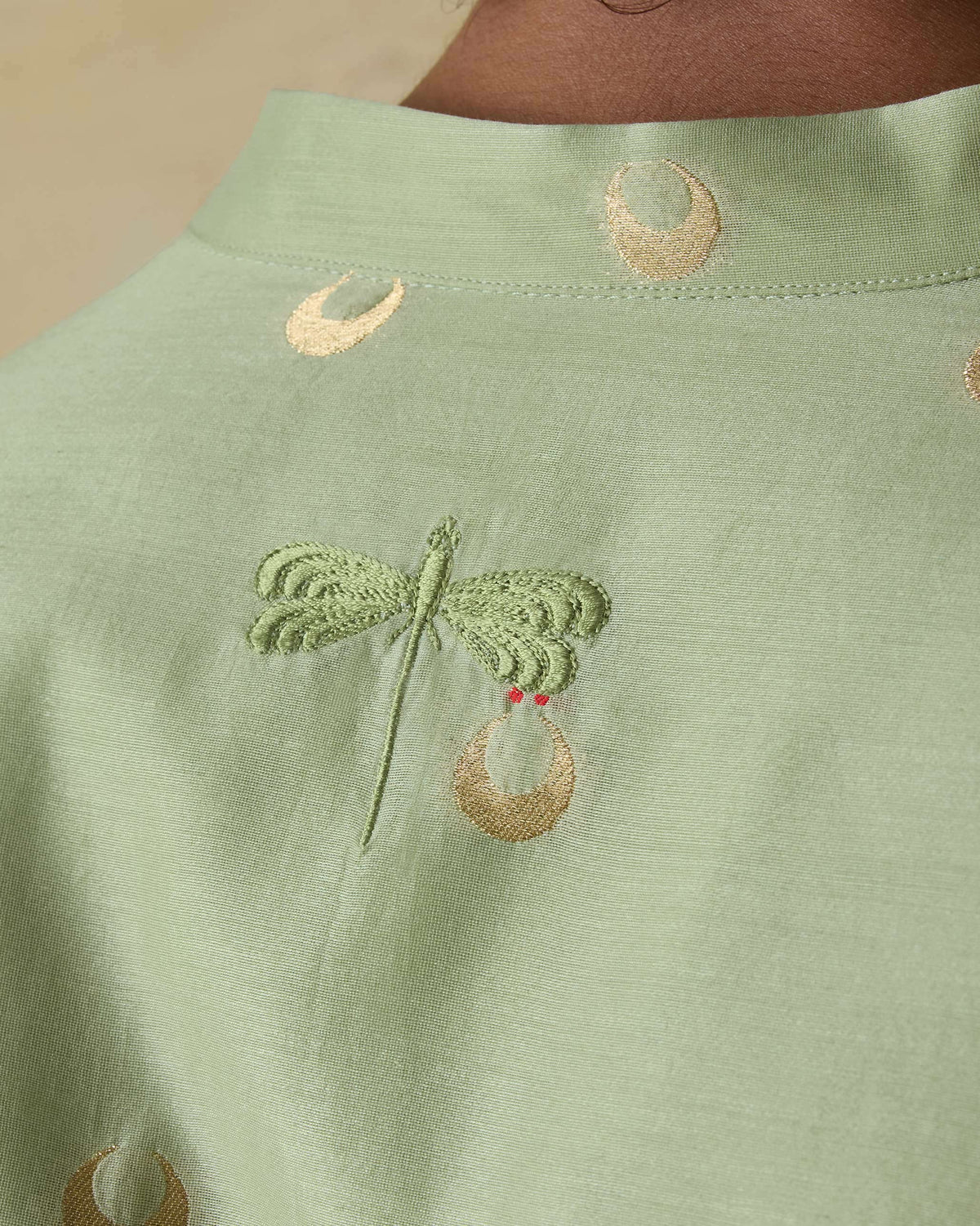 Close-up of a mint green astral kurta back with chartreuse dragonfly embroidery.