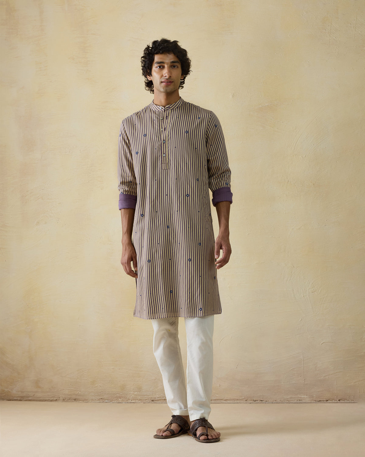 Person wearing a striped Shaam Kurta with blue motifs and purple cuff lining.